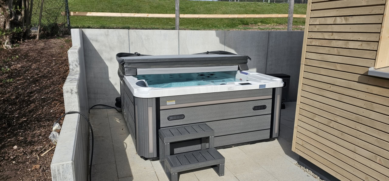 Einbringen des Whirlpools mit einem Manitou-Teleskoplader über Beton-L-Steine in Tennenbronn